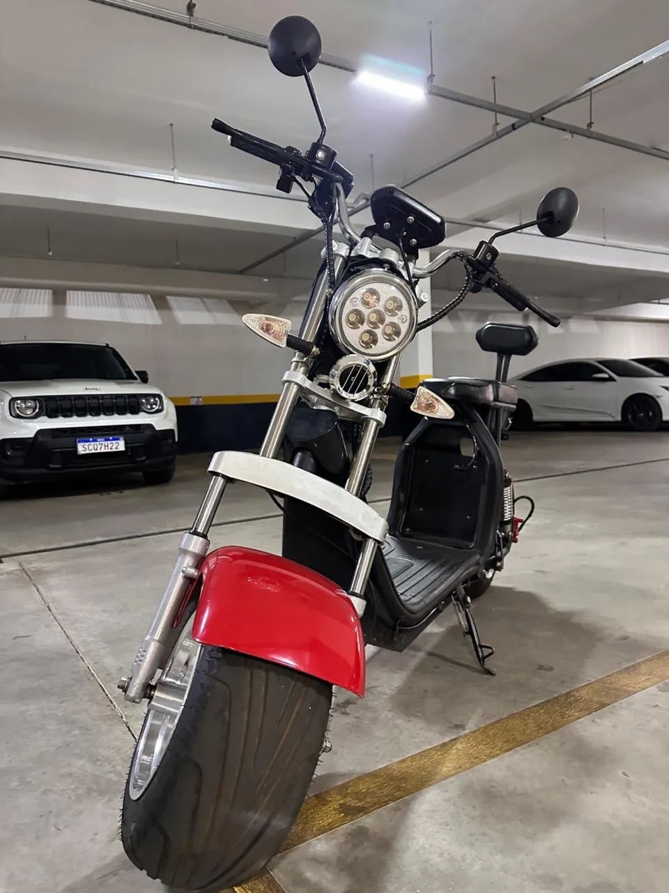 Scooter elétrica marrom em frente a prédio